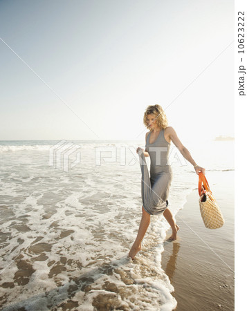 Attractive young woman walking on sandy beach Attractive young woman walking on sandy beach 10623222
