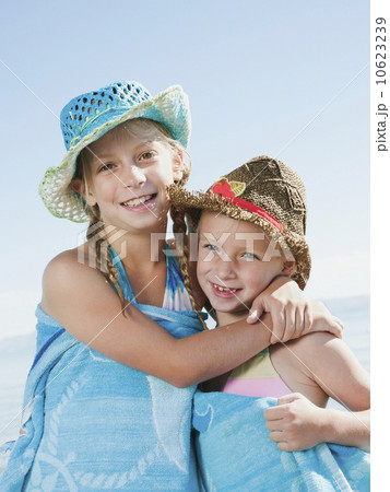 Portrait of girls (6-7,8-9) wrapped in towel on beach Portrait of girls (6-7,8-9) wrapped in towel on beach 10623239