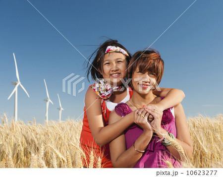 USA, Oregon, Wasco, Girl (10-11) and mother standing in wheat field in front of wind turbines USA, Oregon, Wasco, Girl (10-11) and mother standing in wheat field in front of wind turbines 10623277