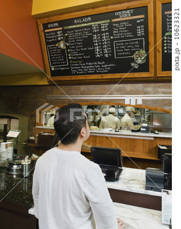 Customer reading chalkboard menu 10623321