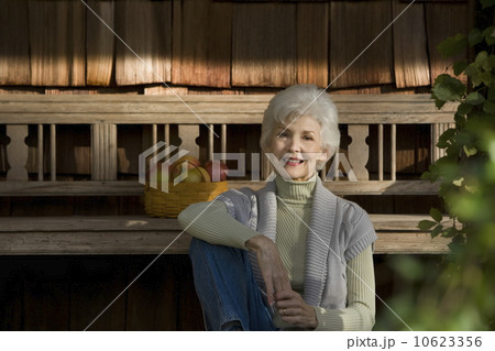 Portrait of senior woman relaxing outside home 10623356