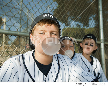 USA, California, Ladera Ranch, Boys (10-11) from little league sitting on dugout and blowing bubble gum USA, California, Ladera Ranch, Boys (10-11) from little league sitting on dugout and blowing bubble gum 10623387