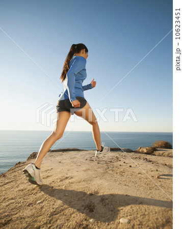 USA, California, San Diego, Woman jogging along sea coast 10623451