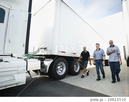 Three men walking between trucks 10623510