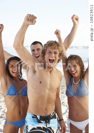 Young friends raising arms on beach Young friends raising arms on beach 10623611