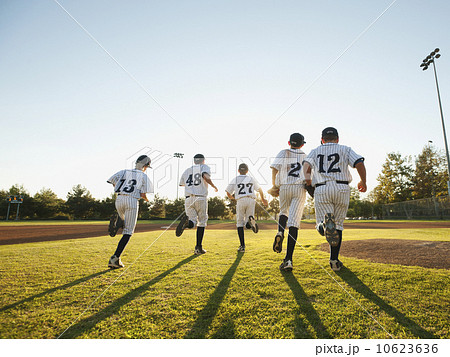 Baseball players (10-11) running on baseball diamond 10623636