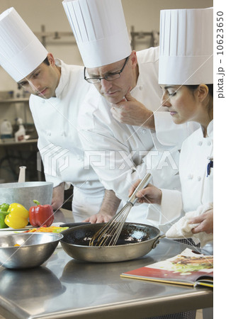 Head chef inspecting cooking techniques 10623650