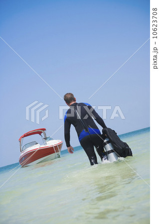 Man carrying scuba gear towards boat, Florida, United States Man carrying scuba gear towards boat, Florida, United States 10623708