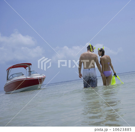 Couple with snorkeling gear walking in water, Florida, United States 10623885