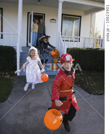 Children dressed in Halloween costumes leaving house Children dressed in Halloween costumes leaving house 10623901