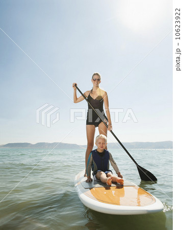 Portrait of young woman with daughter (4-5) on paddleboard 10623922