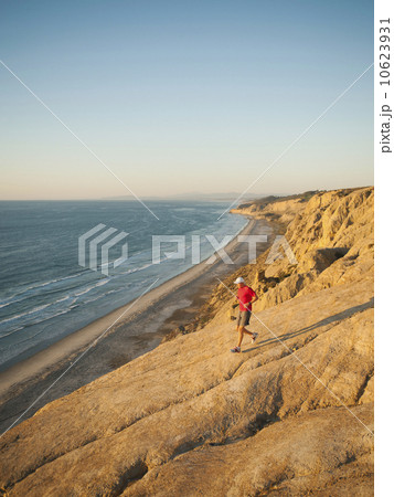USA, California, San Diego, Man jogging along sea coast 10623931