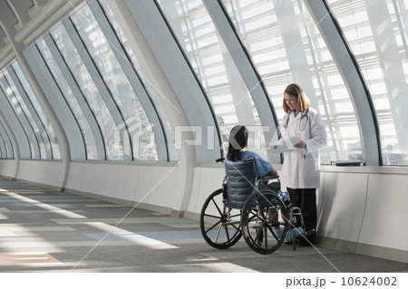 USA, Virginia, Virginia Beach, doctor talking to patient in wheelchair 10624002