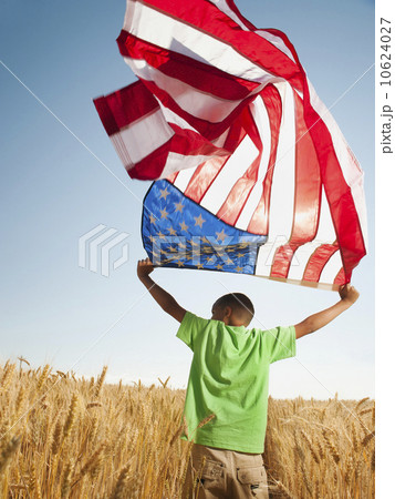 USA, Oregon, Wasco, Boy (8-9) flying american flag in wheat field with wind turbines in background USA, Oregon, Wasco, Boy (8-9) flying american flag in wheat field with wind turbines in background 10624027