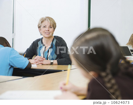 Teacher watching over students in elementary classroom 10624073