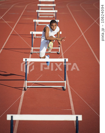 Boy (12-13) hurdling on running track Boy (12-13) hurdling on running track 10624094