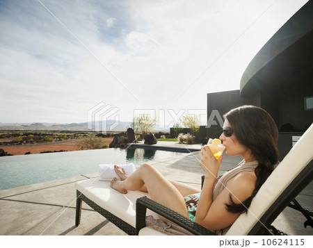Young attractive woman enjoying cocktail by swimming pool 10624115