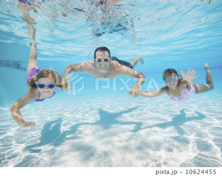 Father with two daughters (6-7,8-9) swimming underwater Father with two daughters (6-7,8-9) swimming underwater 10624455