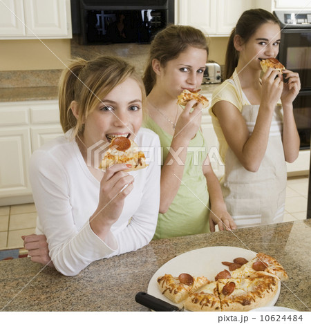 Teenaged girls eating pizza 10624484