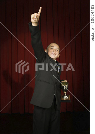 Boy holding trophy on stage Boy holding trophy on stage 10624485