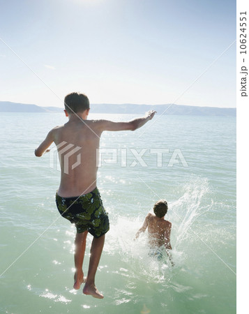 Boys (10-11,12-13) jumping into lake 10624551