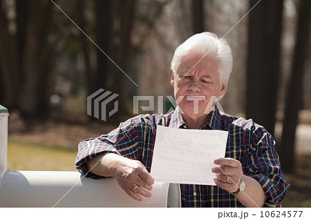 USA, Virginia, Richmond, senior man reading letter by mailbox 10624577