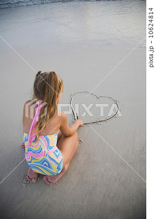 Girl drawing heart in sand, Florida, United States 10624814