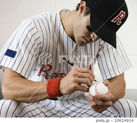 Close up of baseball player autographing baseball Close up of baseball player autographing baseball 10624914
