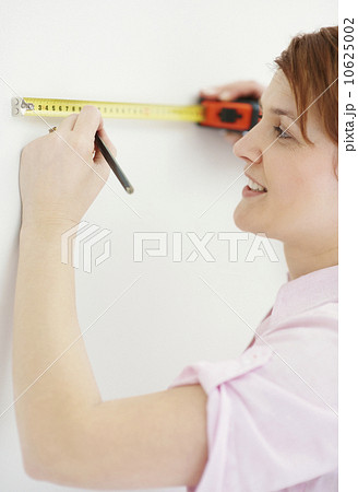 Woman using measuring tape Woman using measuring tape 10625002