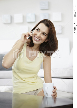 Smiling brunette woman talking on phone 10625029