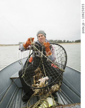 Portrait of man holding crabs in net Portrait of man holding crabs in net 10625055