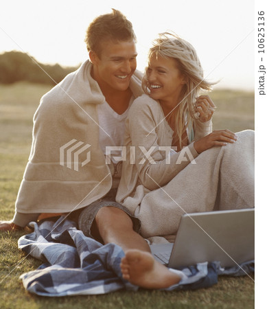 Couple looking at laptop outdoors 10625136