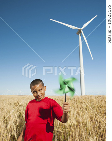 USA, Oregon, Wasco, Girl (10-11) holding fan in wheat field with wind turbines in background USA, Oregon, Wasco, Girl (10-11) holding fan in wheat field with wind turbines in background 10625185
