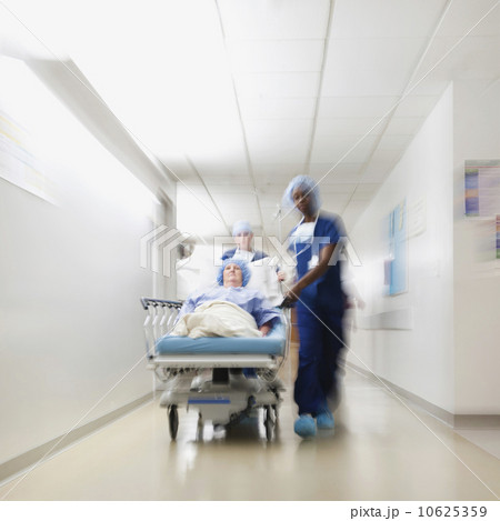 Senior woman being taken to operating room by medical staff 10625359