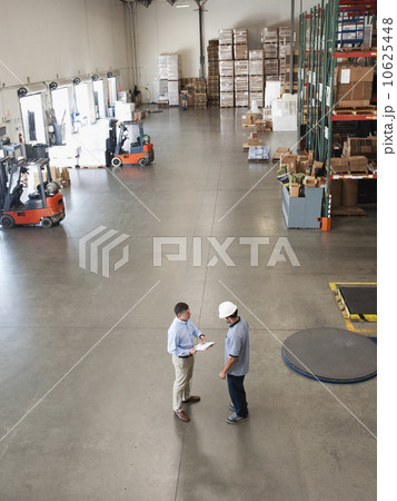 Workers talking in warehouse Workers talking in warehouse 10625448