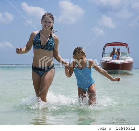 Sisters running through water, Florida, United States Sisters running through water, Florida, United States 10625512