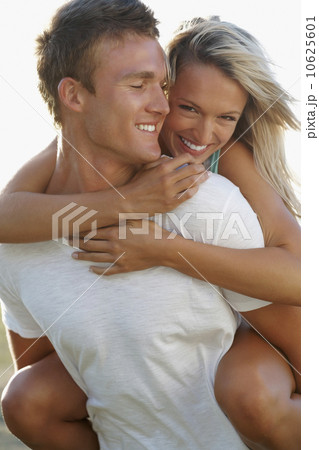 Man giving girlfriend a piggy back ride Man giving girlfriend a piggy back ride 10625601