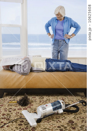 Woman looking at man sleeping next to vacuum 10625608