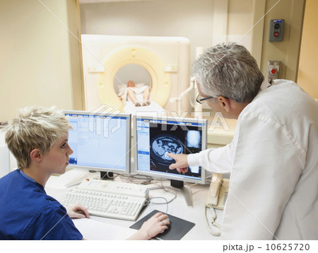 Doctor and nurse looking at CAT scan of patient's brain 10625720