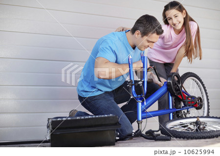 Father with daughter (10-11) fixing bike Father with daughter (10-11) fixing bike 10625994