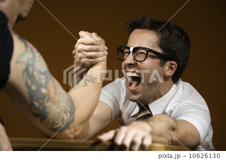 Nerdy man arm wrestling tattooed man Nerdy man arm wrestling tattooed man 10626130