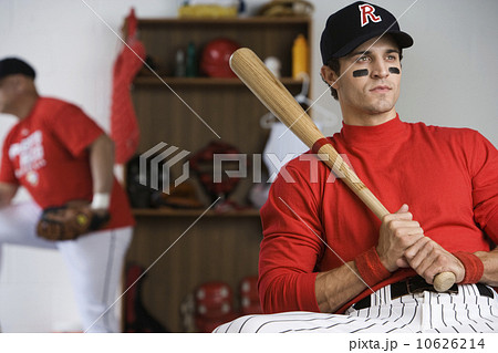 Baseball player holding bat in locker room Baseball player holding bat in locker room 10626214