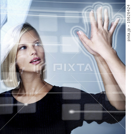 Young woman using futuristic touchscreen, studio shot Young woman using futuristic touchscreen, studio shot 10626424
