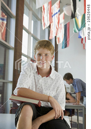 Boy holding book in library 10626448