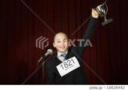 Boy wearing number and holding trophy 10626482