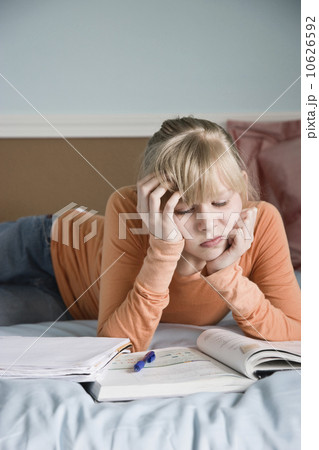 Girl doing homework on bed Girl doing homework on bed 10626592