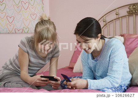 Girls looking at cell phones Girls looking at cell phones 10626627