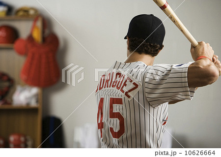 Baseball player practicing swing in locker room Baseball player practicing swing in locker room 10626664