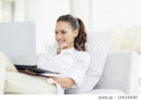 Woman relaxing on couch with laptop 10626680