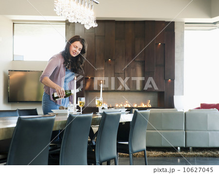 Young attractive woman pouring champagne into glasses 10627045